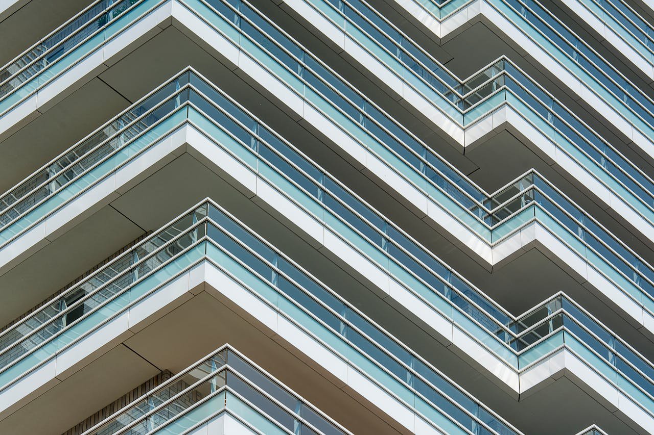 Services Close-up view of modern apartment building facade with glass balconies in an urban setting.